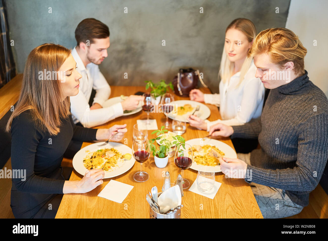 Les jeunes gens en train de déjeuner ensemble ou en train de dîner au restaurant Banque D'Images