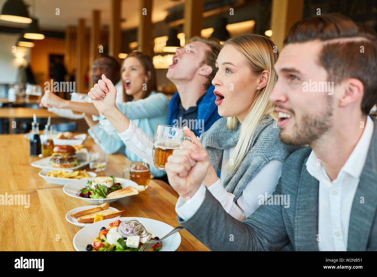 Les jeunes regarder match de football dans un bar ou restaurant Banque D'Images
