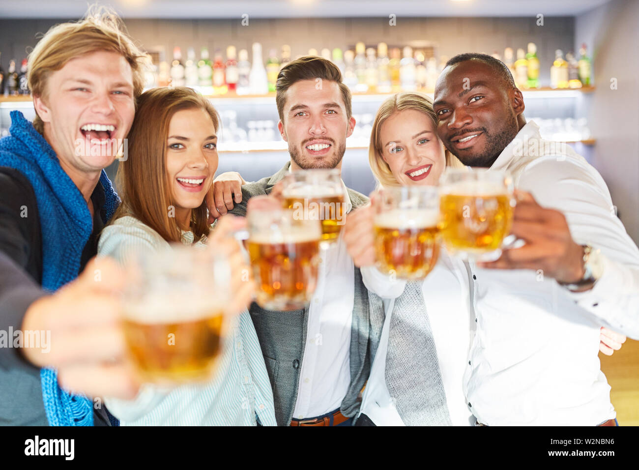 Rire groupe d'amis de boire une bière au pub dans une humeur gaie Banque D'Images