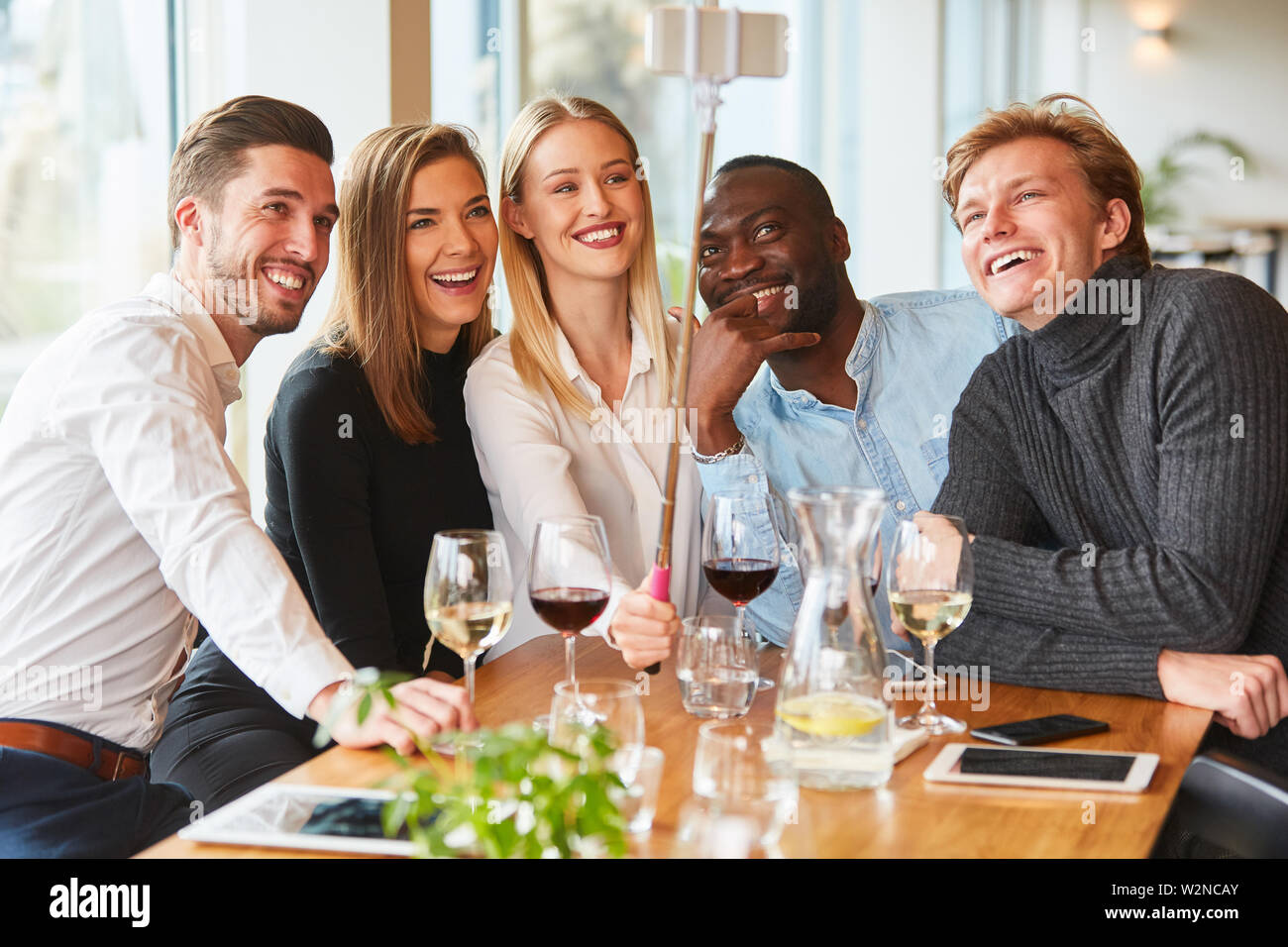 Les jeunes prennent une photo avec les selfies stick selfies au restaurant ou pub Banque D'Images