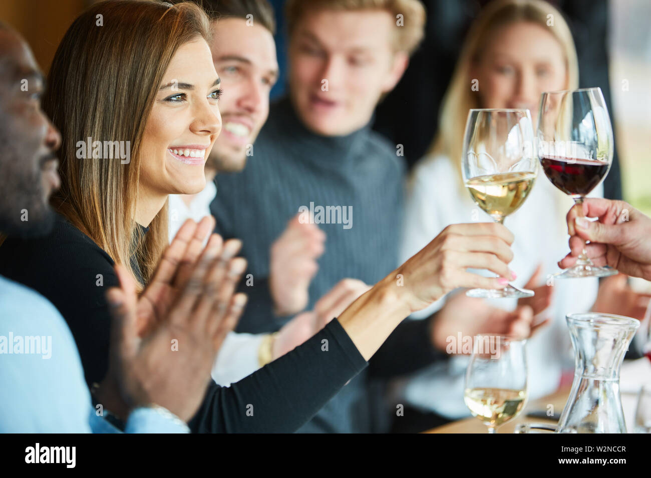 Jeune femme la dégustation et le grillage avec un verre de vin dans le restaurant Banque D'Images