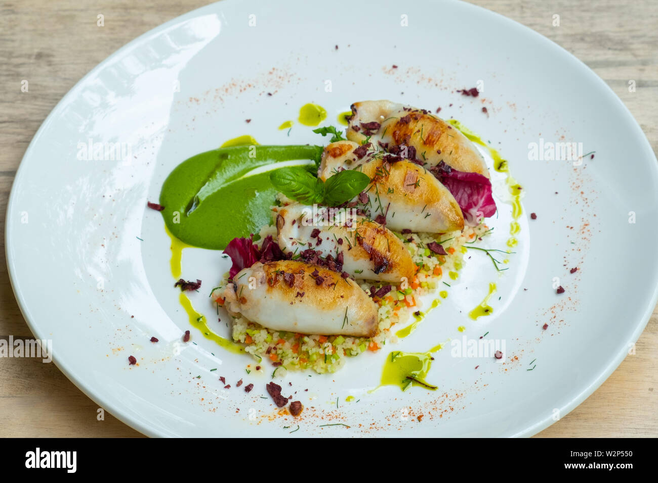 Close up de calmars farcis calmars,Servi avec couscous, olives, légumes, purée de courgettes, le basilic crème fraîche et herbes bio,huile d'olive, foo sain Banque D'Images