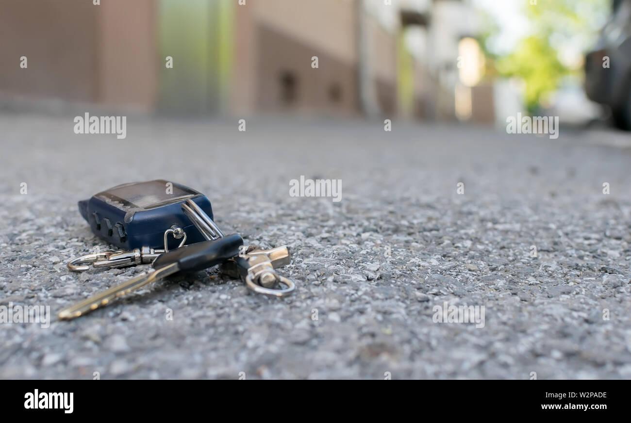 Le trousseau perdu, télécommande alarme antivol voiture, se trouve sur le  trottoir de la route asphaltée, près de l'entrée d'une maison avec les  voitures en stationnement Photo Stock - Alamy