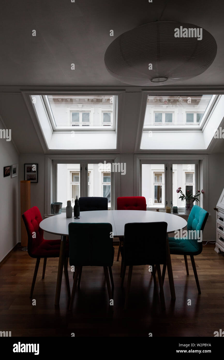 Scandinavian salle à manger avec table et chaises par de grandes fenêtres. Banque D'Images