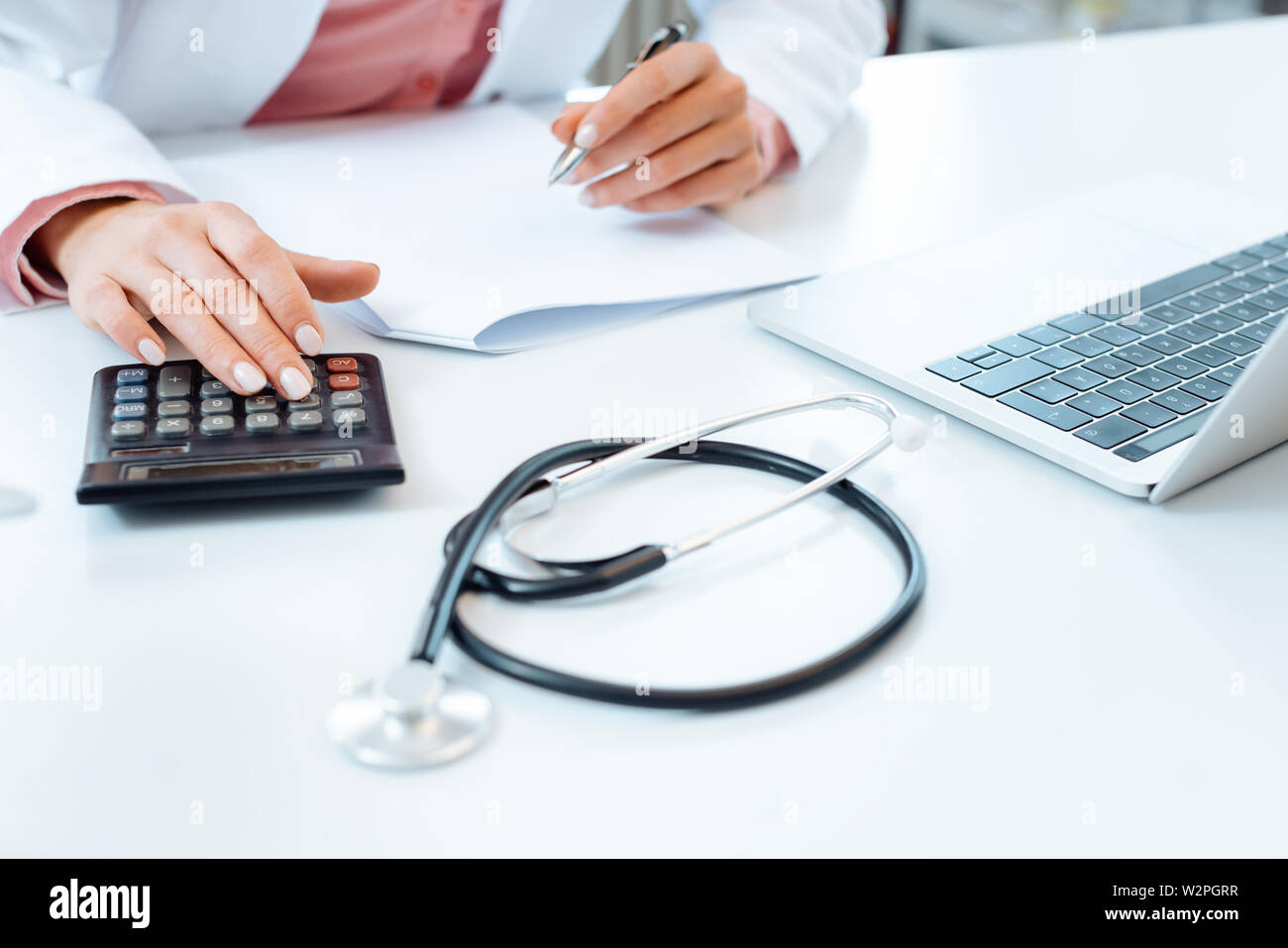 Médecin à l'aide de factures et de faire l'écriture calculatrice comptabilité Banque D'Images