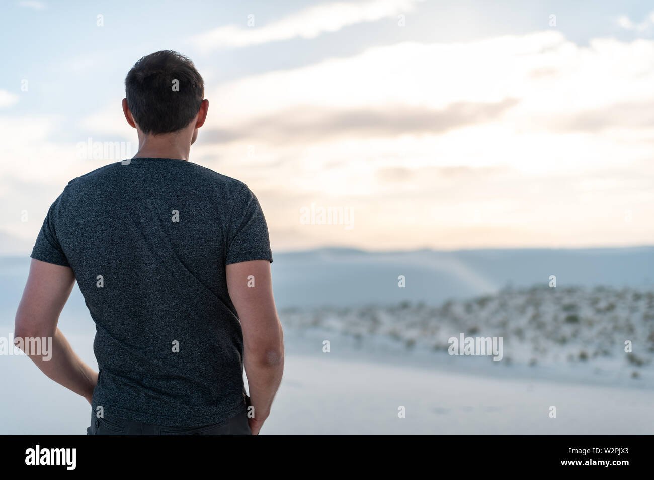 L'homme libre permanent sur le sable en dunes de sable blanc national monument dans le Nouveau Mexique à l'horizon au coucher du soleil sur les montagnes et d'organes Banque D'Images
