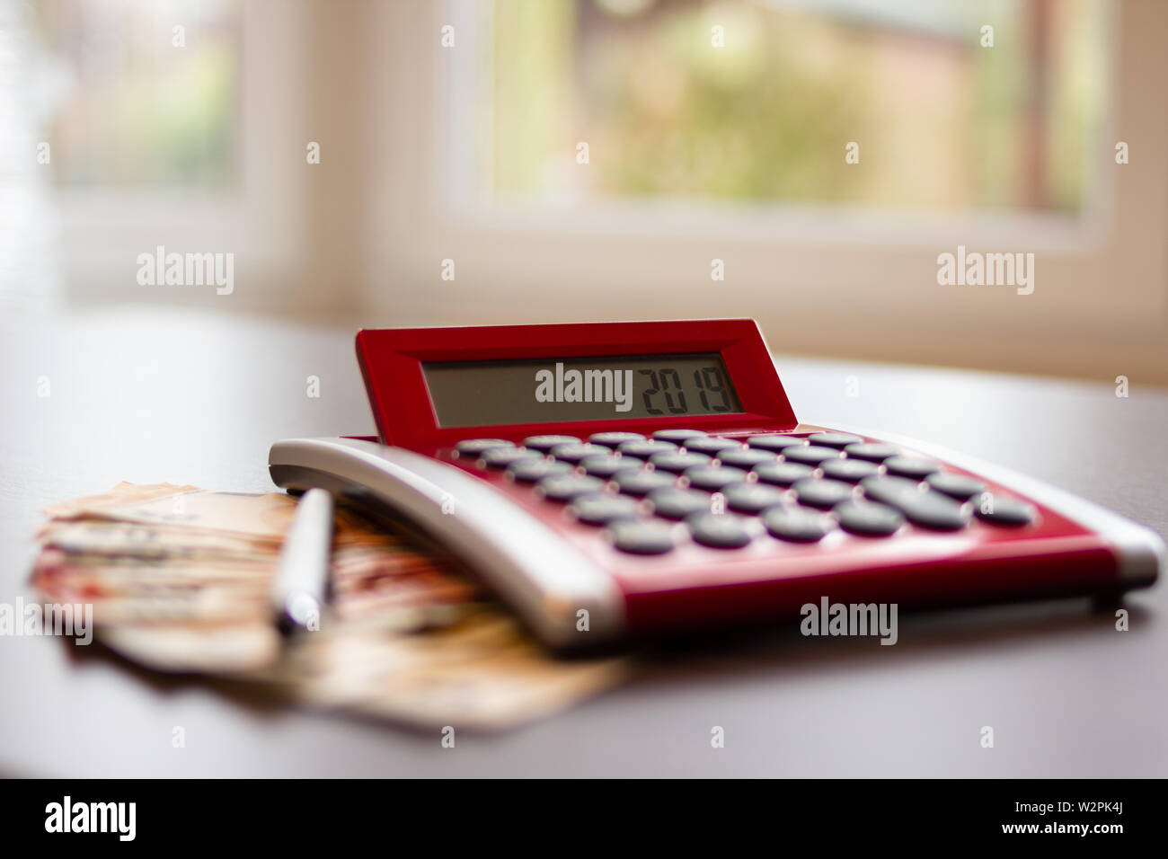 Concept de planification budgétaire. Calculatrice, billets d'euros et d'un stylo sur une table au home office Banque D'Images