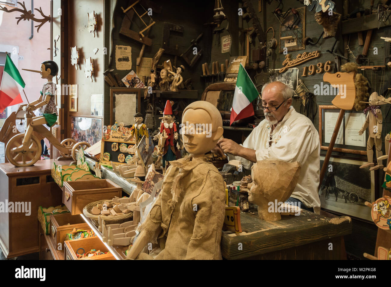 Menuisier italien travaillant sur Pinocchio jouets en bois dans son atelier/magasin, ouvert au public Banque D'Images