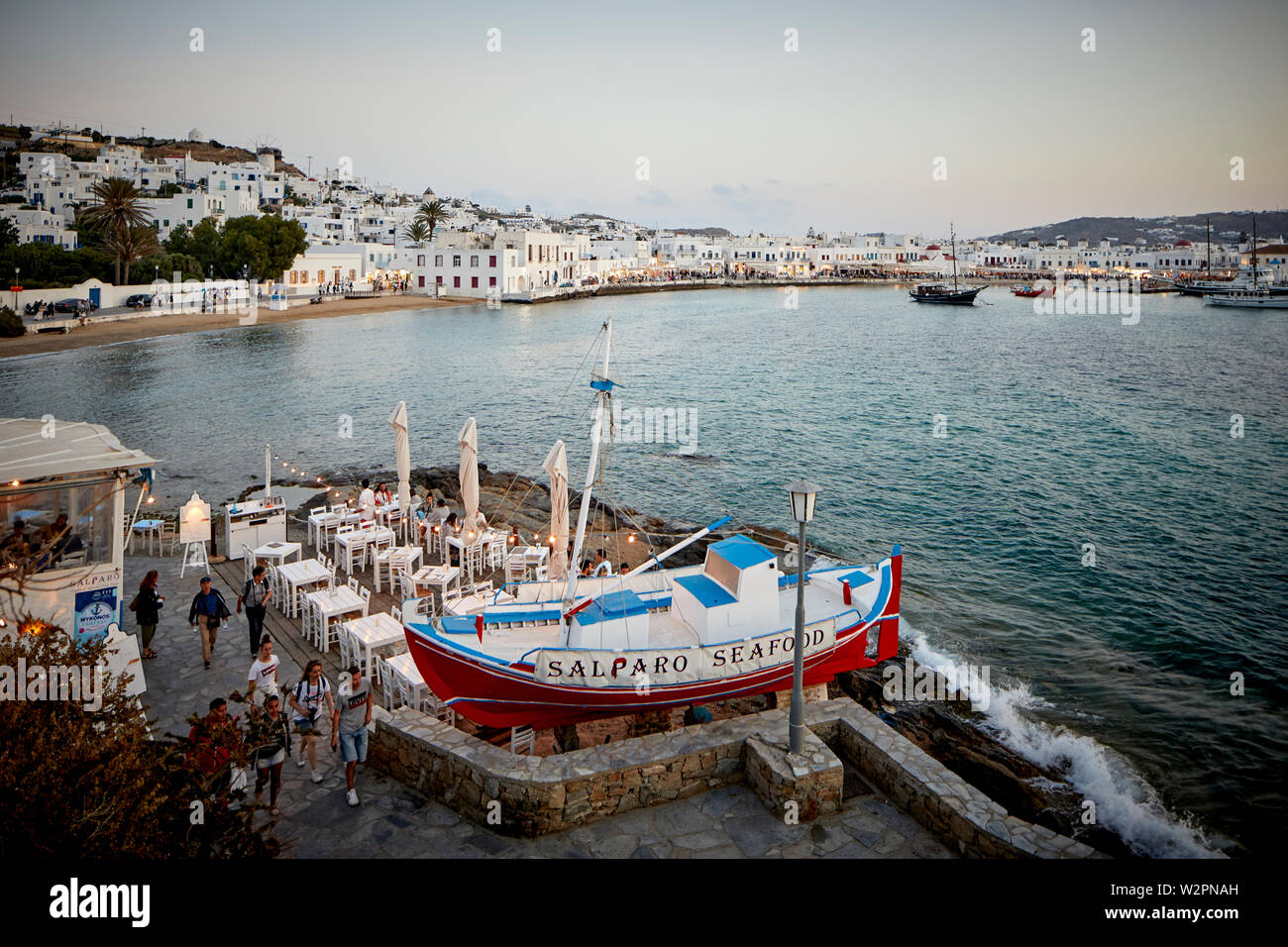 Mykonos, l'île grecque de Mikonos, partie des Cyclades, Grèce. harbour restaurant de plage au coucher du soleil Banque D'Images Mykonos, l'île grecque de Mikonos, partie des Cyclades, Grèce. harbour restaurant de plage au coucher du soleil Banque D'Images