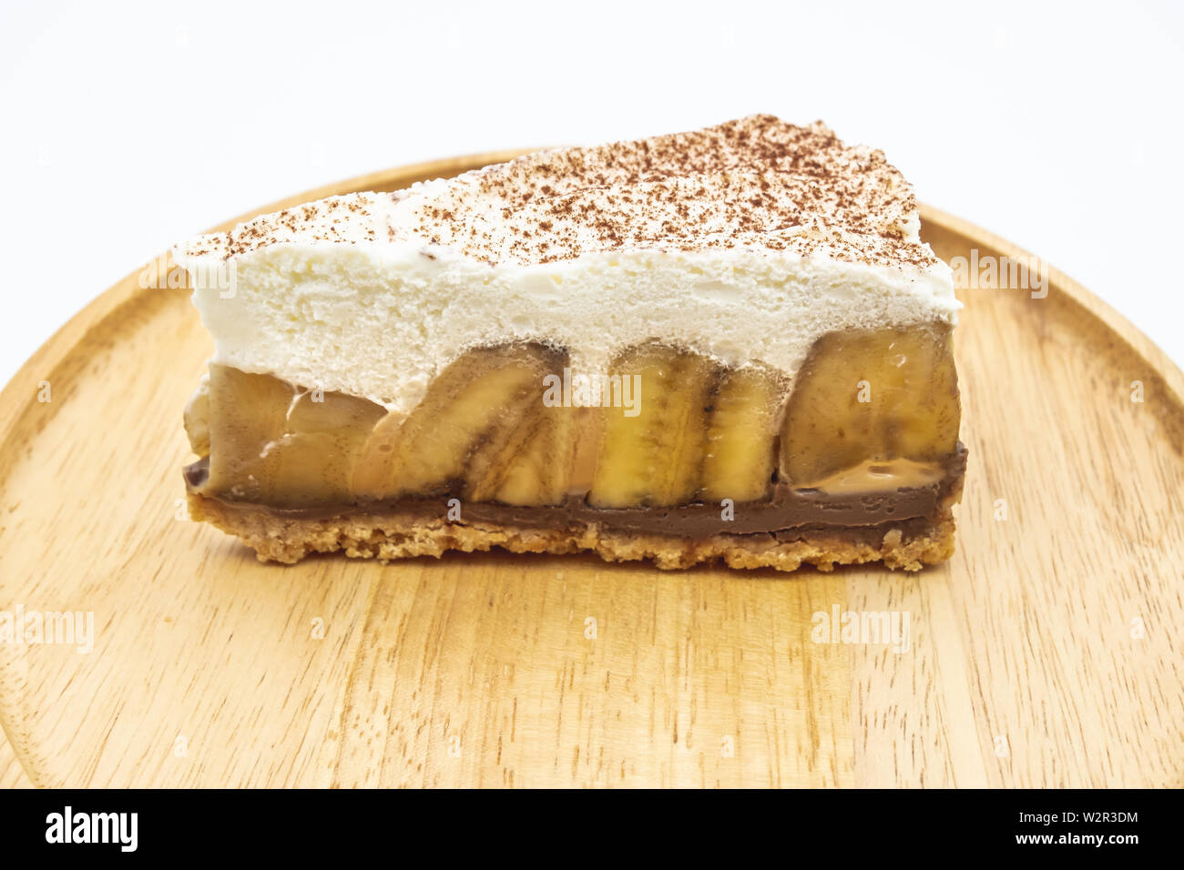 Banoffee Pie, crème fouettée et banane sur la plaque en bois isoler fond blanc Banque D'Images