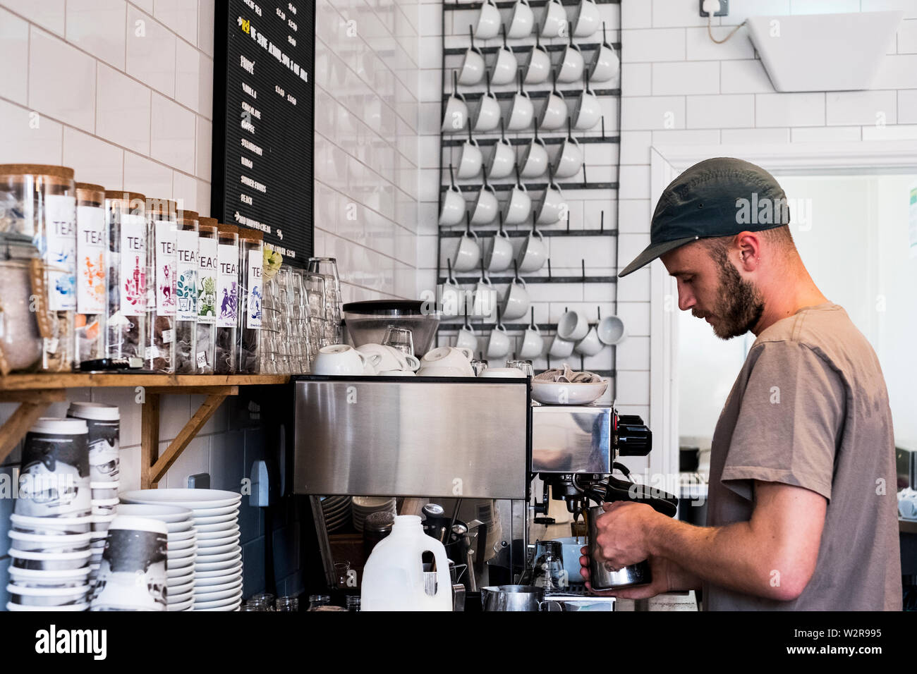 Un homme d'une machine à café barista travaillant dans un café. Banque D'Images