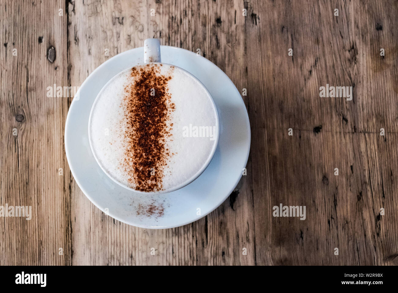 Une tasse de café dans un café, un cappuchino avec mousse haut et saupoudré le chocolat en poudre. Banque D'Images