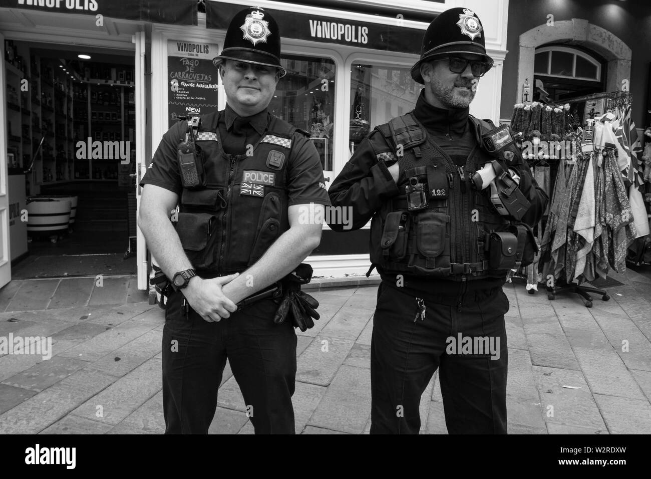 Les policiers locaux à Gibraltar lunettes de soleil chapeau chapeaux souriant copers policiers bobbies Anglais British magasin de vêtements rue à l'extérieur gants radio Banque D'Images