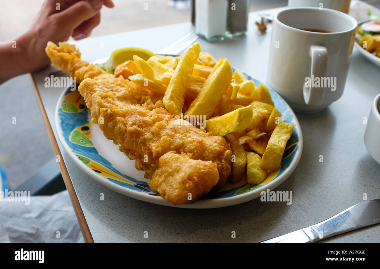 Littlehampton West Sussex UK - Manger des plats préparés de la morue et de jetons à un café du port, avec une tasse de thé Banque D'Images