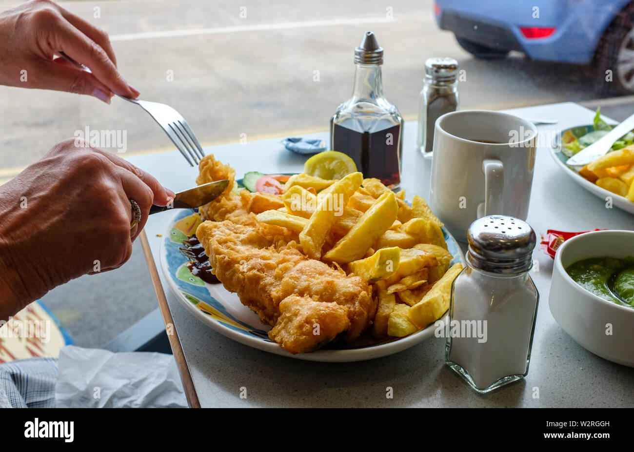 Littlehampton West Sussex UK - Manger des plats préparés de la morue et de jetons à un café du port, avec une tasse de thé Banque D'Images