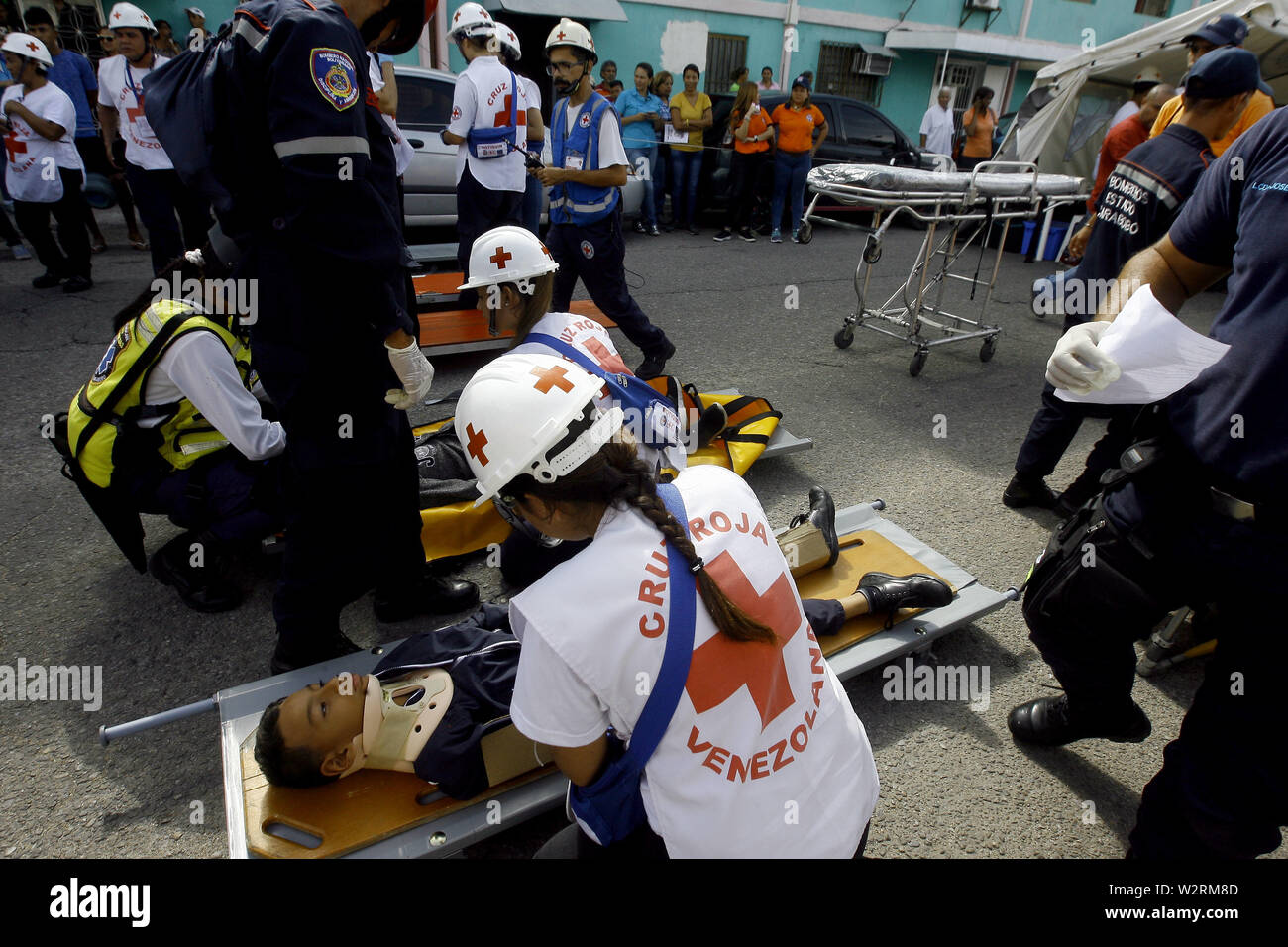 Valencia, Carabobo, Venezuela. 10 juillet, 2019. Le 10 juillet 2019. Les enfants qui sont les victimes présumées sont servis par des membres de groupes de secours au cours d'une simulation de tremblement de terre qui a eu lieu dans le secteur de l'époque élisabéthaine, où les étudiants et les enseignants des différentes écoles de la région ont participé, ainsi que les résidents. Les forces de sécurité participants appartiennent à un système intégré et sont constitués de protestation civile, les pompiers, la Croix-Rouge, la police d'État et municipaux, ainsi que les responsables du transport en commun de masse. À Valence, l'État de Carabobo. Photo : Juan Carlos Hernandez (crédit Image : © Jua Banque D'Images