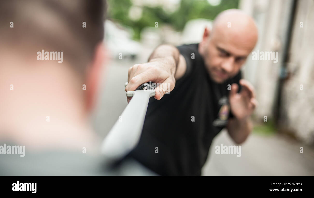 L'Eskrima et wushu démontre l'instructeur technique de combat à la machette avec son élève. Long Couteau arme de la formation. Démonstration avec l'épée en plastique Banque D'Images