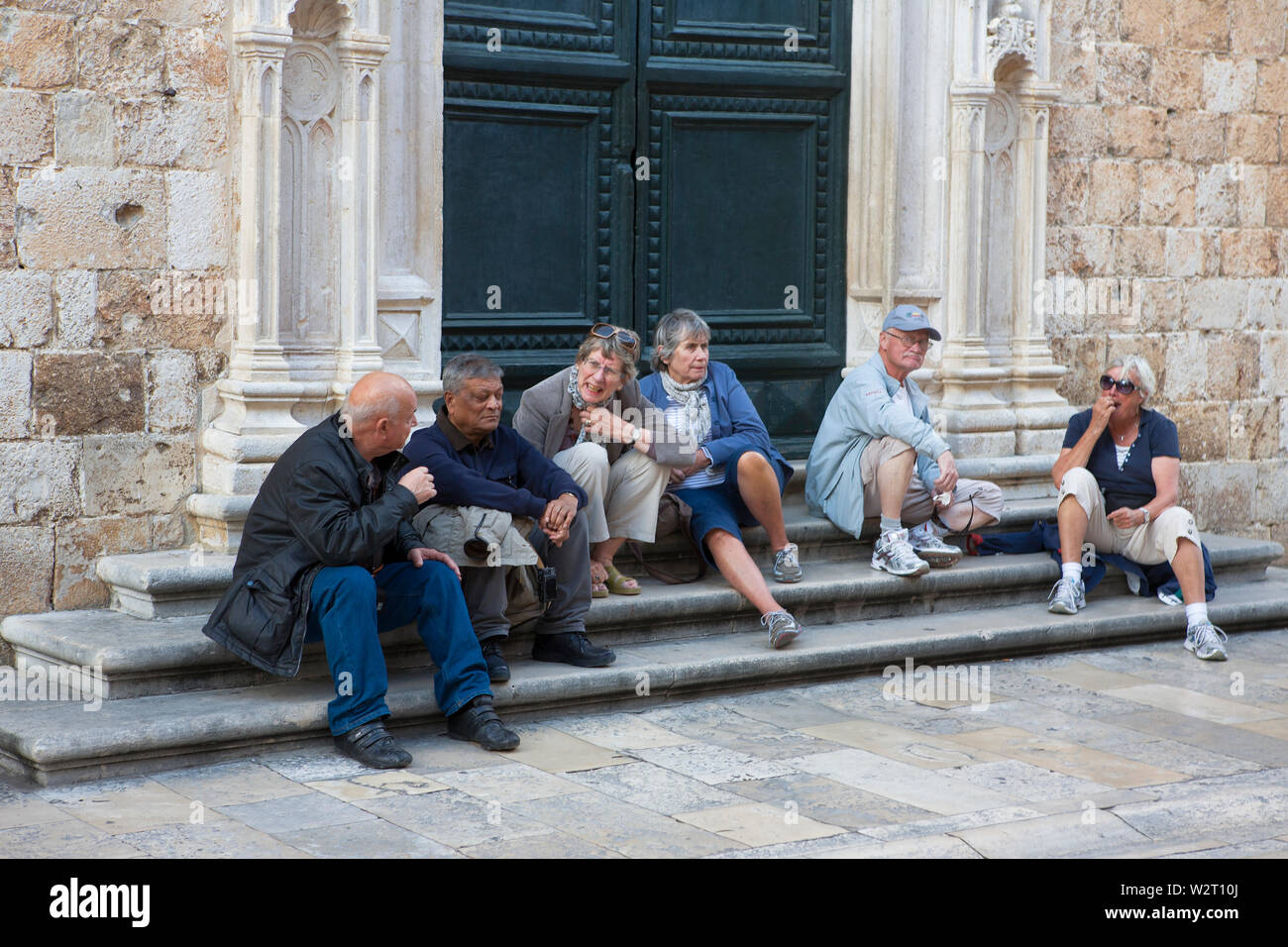 Se reposer sur les marches de l'église du monastère franciscain, Stradun, vieille ville (Stari Grad), Dubrovnik, Croatie Banque D'Images