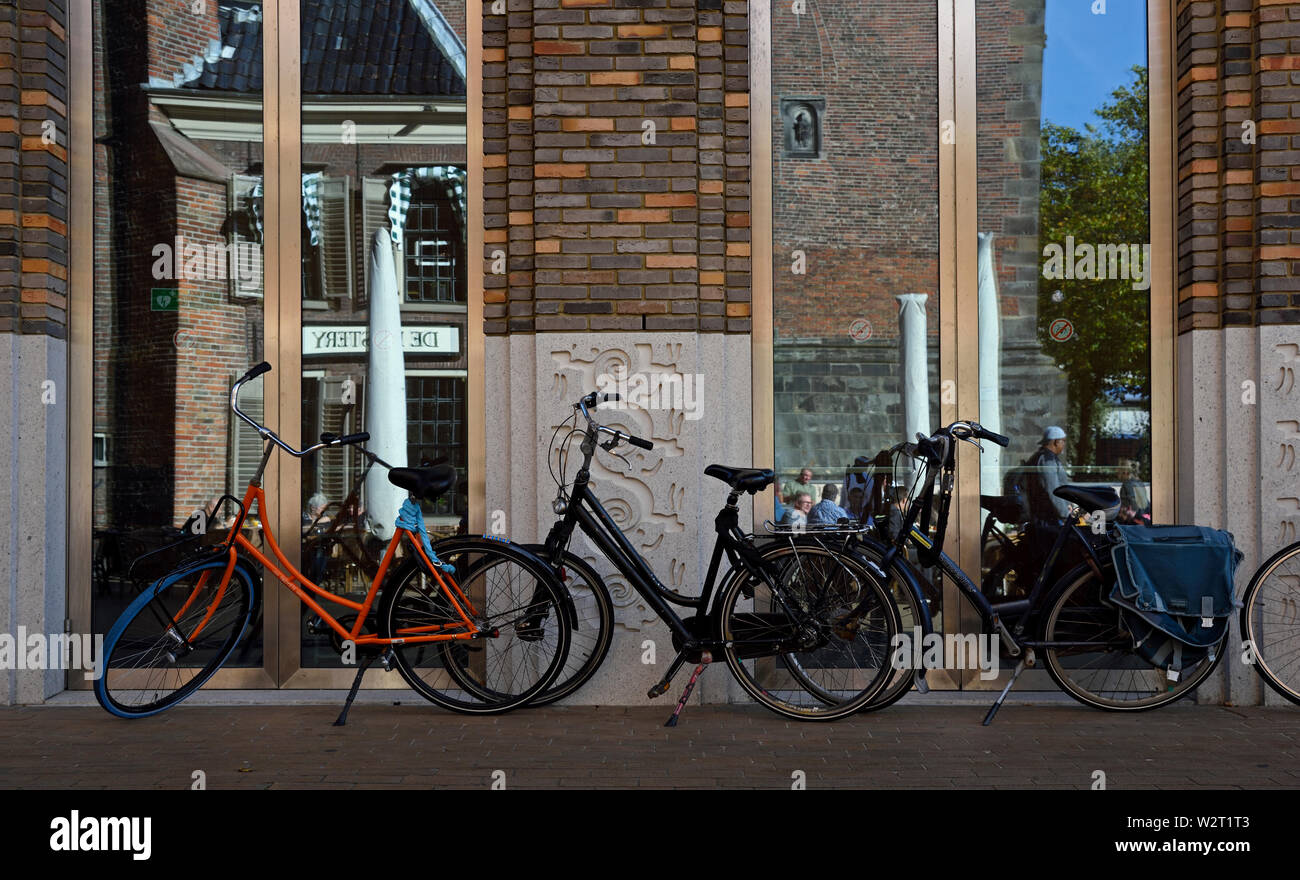 Groningen, Groningen/Pays-Bas - 12 octobre 2018 : bicyclettes garées en face de portes de verre reflétant la façade de l'église martini historique ( mart Banque D'Images