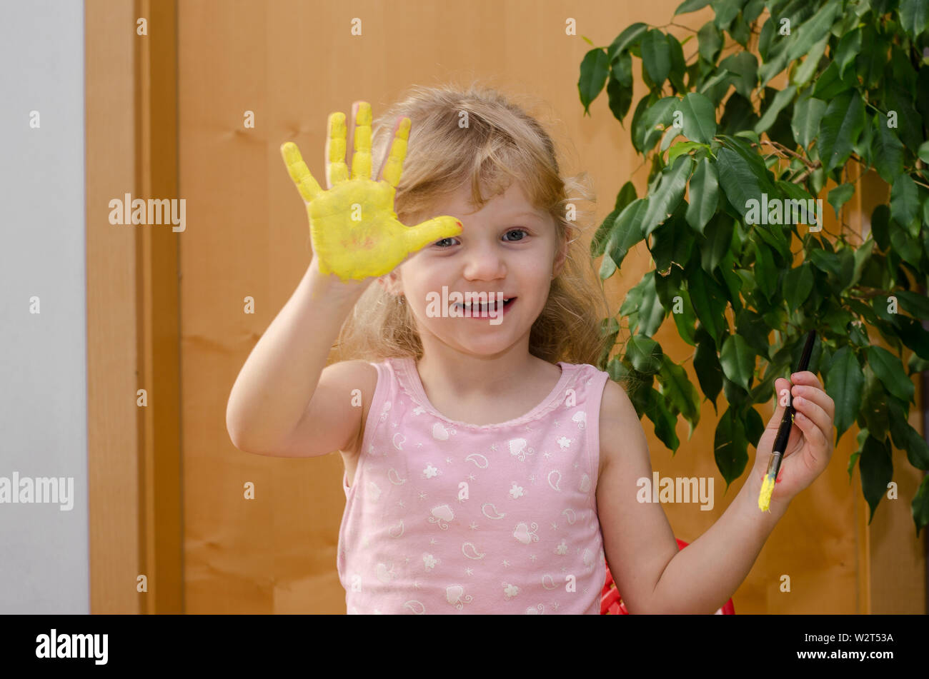 Fille blonde avec soleil peint sur sa main Banque D'Images