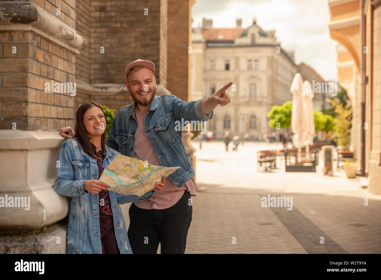 Deux amis, ou en couple, à la recherche d'un plan de la ville tandis que l'homme est un doigt pointé. Location Novi Sad, Serbie. Banque D'Images