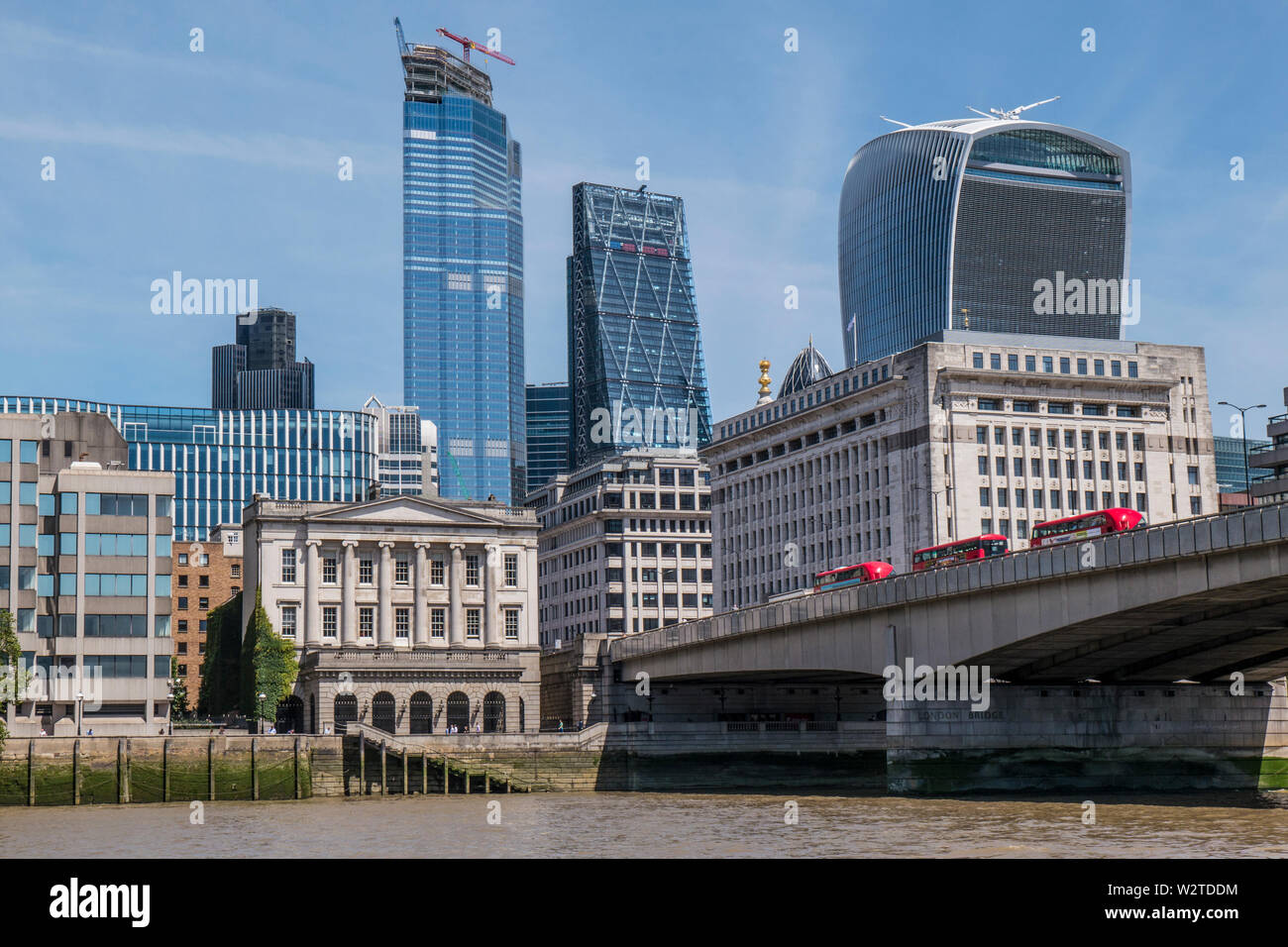 Le Pont de Londres avec Red bus menant à la ville de Londres les bâtiments financiers architecture ancienne et nouvelle. Gratte-ciel Skyline et la construction d'immeubles de bureaux dans la ville de Londres. Vue sur la ville d'immeubles de grande hauteur vue à partir de la Tamise Londres Banque D'Images