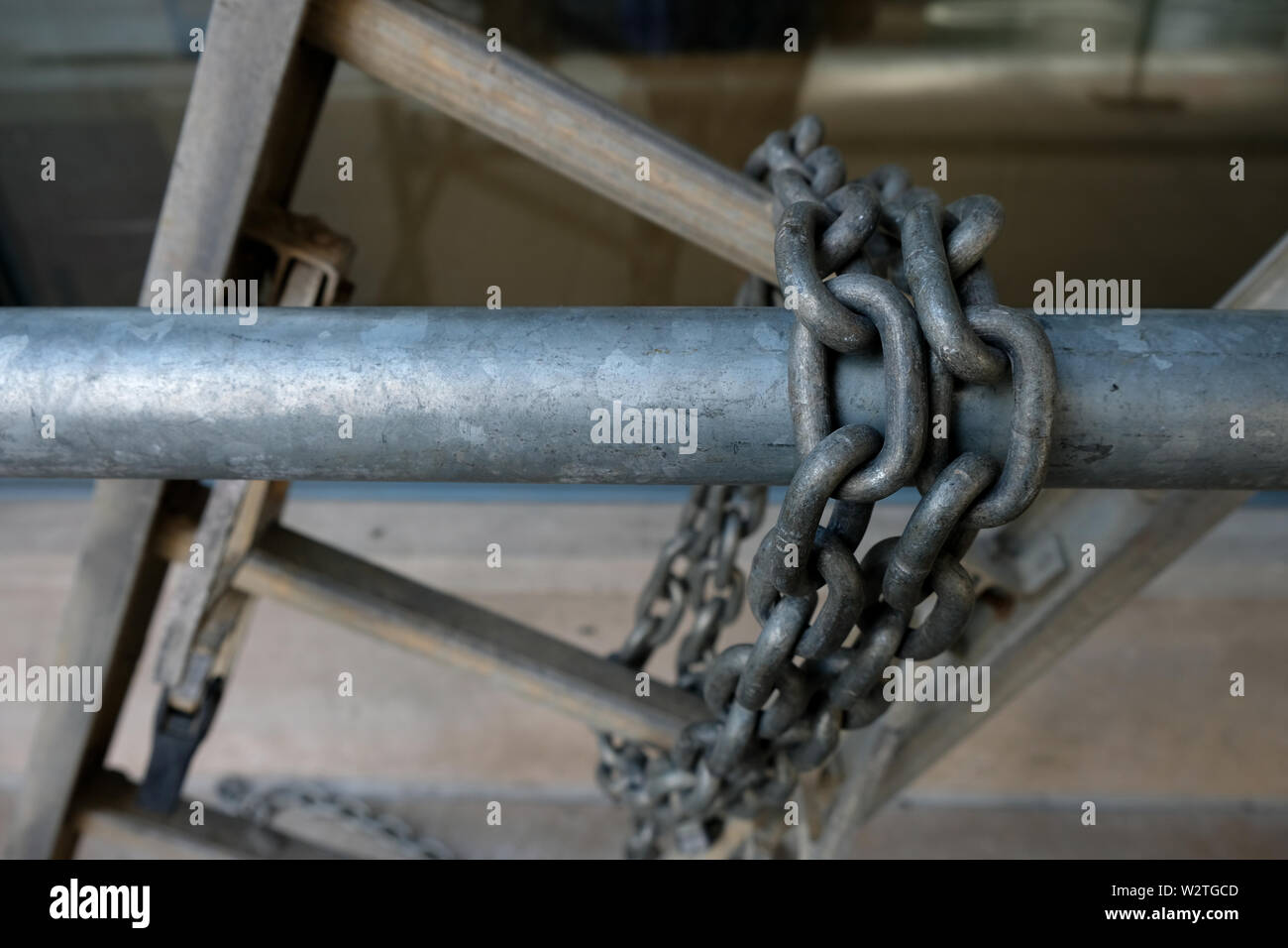 Une échelle en métal est enchaîné à un tuyau d'argent à l'aide d'une lourde  chaîne argent Photo Stock - Alamy