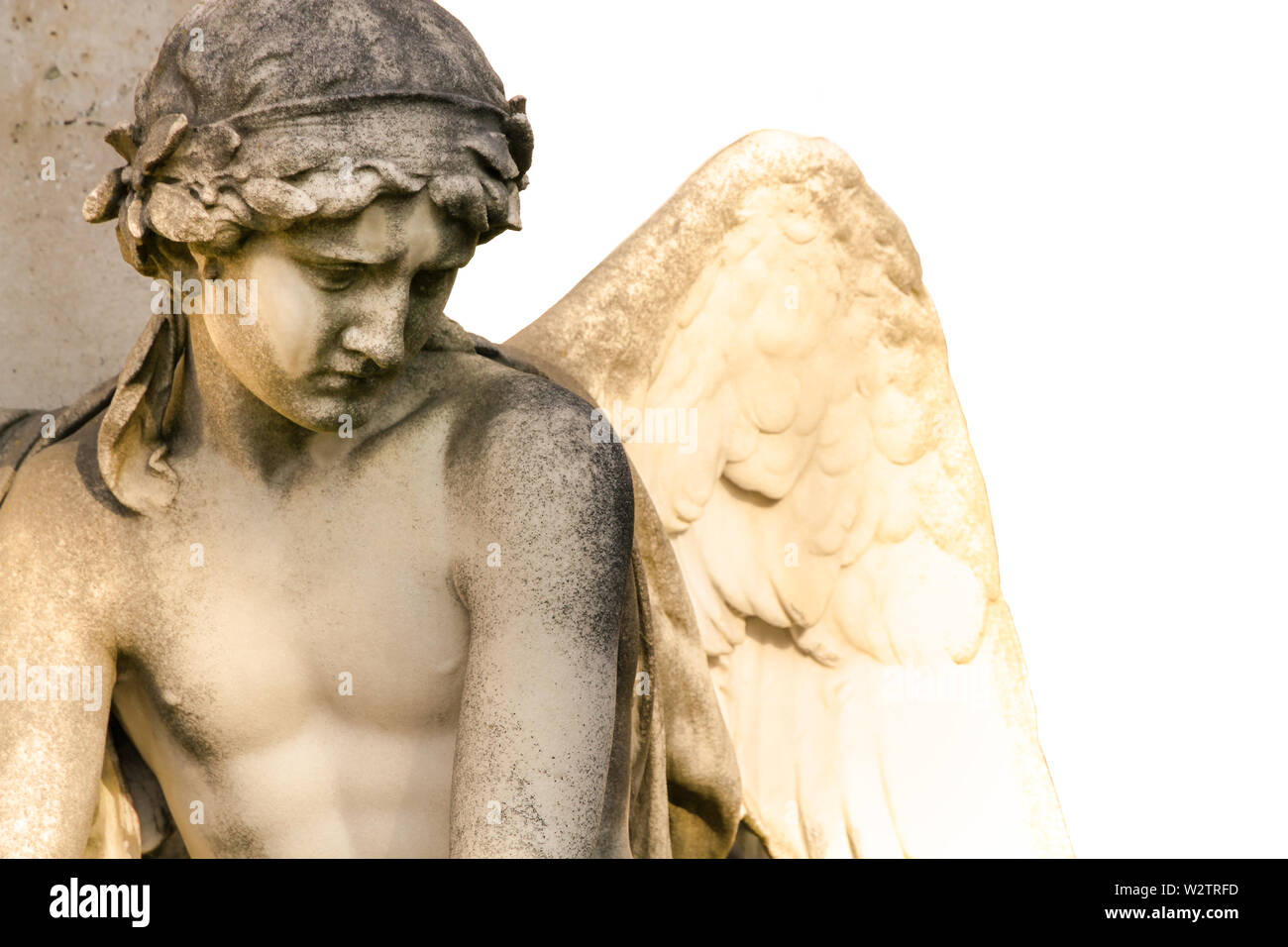 Ange avec des ailes sous la lumière du soleil naturel. Triste ange gardien sculpture avec open wings isolé sur fond blanc. L'expression triste sculpture avec Banque D'Images