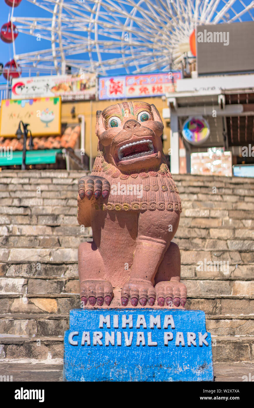 Shisa Okinawan lion et Mihama Carnival Park Grande roue situé dans le quartier de Village américain de la ville de Chatan, ornée de palmiers Banque D'Images