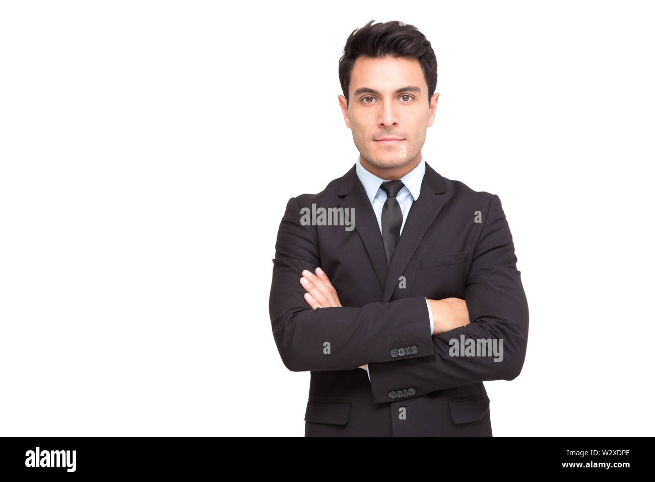 Portrait d'un charmant man dressed in suit posing while standing arms crossed and looking at camera isolated over white background Banque D'Images