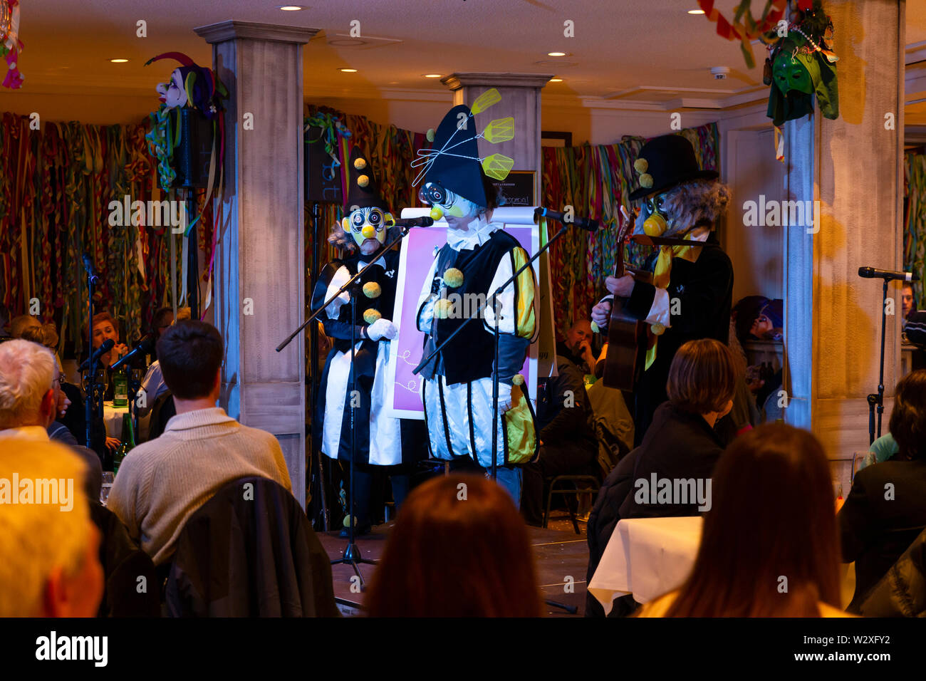 Bâle, Suisse - Mars 11th, 2019. Le Schnitzelbaenggler Carnaval groupe appelé Drey Daags Fliege effectuant leur parodie de la poésie dans un restaurant Banque D'Images