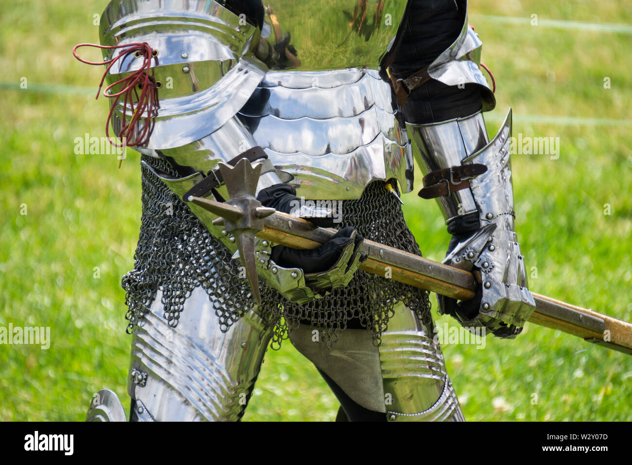 Un chevalier médiéval dans amrour tient une arme Banque D'Images