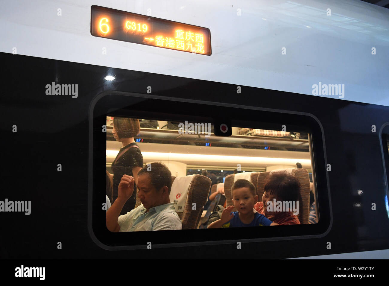 (190711) -- CHONGQING, 11 juillet 2019 (Xinhua) -- Un enfant de vagues à l'intérieur de la fenêtre du train rapide G319 à la gare de l'ouest de Chongqing dans le sud-ouest de la Chine, Chongqing, le 11 juillet 2019. Le bullet train G319 a quitté la gare de l'ouest de Chongqing à 8 h 20 et arrivera à Hong Kong West Kowloon Station autour de 7,5 heures plus tard. Un siège de seconde classe pour les 7,5 heures de voiture coûte 660 yuans (environ 96 dollars américains). (Xinhua/Tang Yi) Banque D'Images