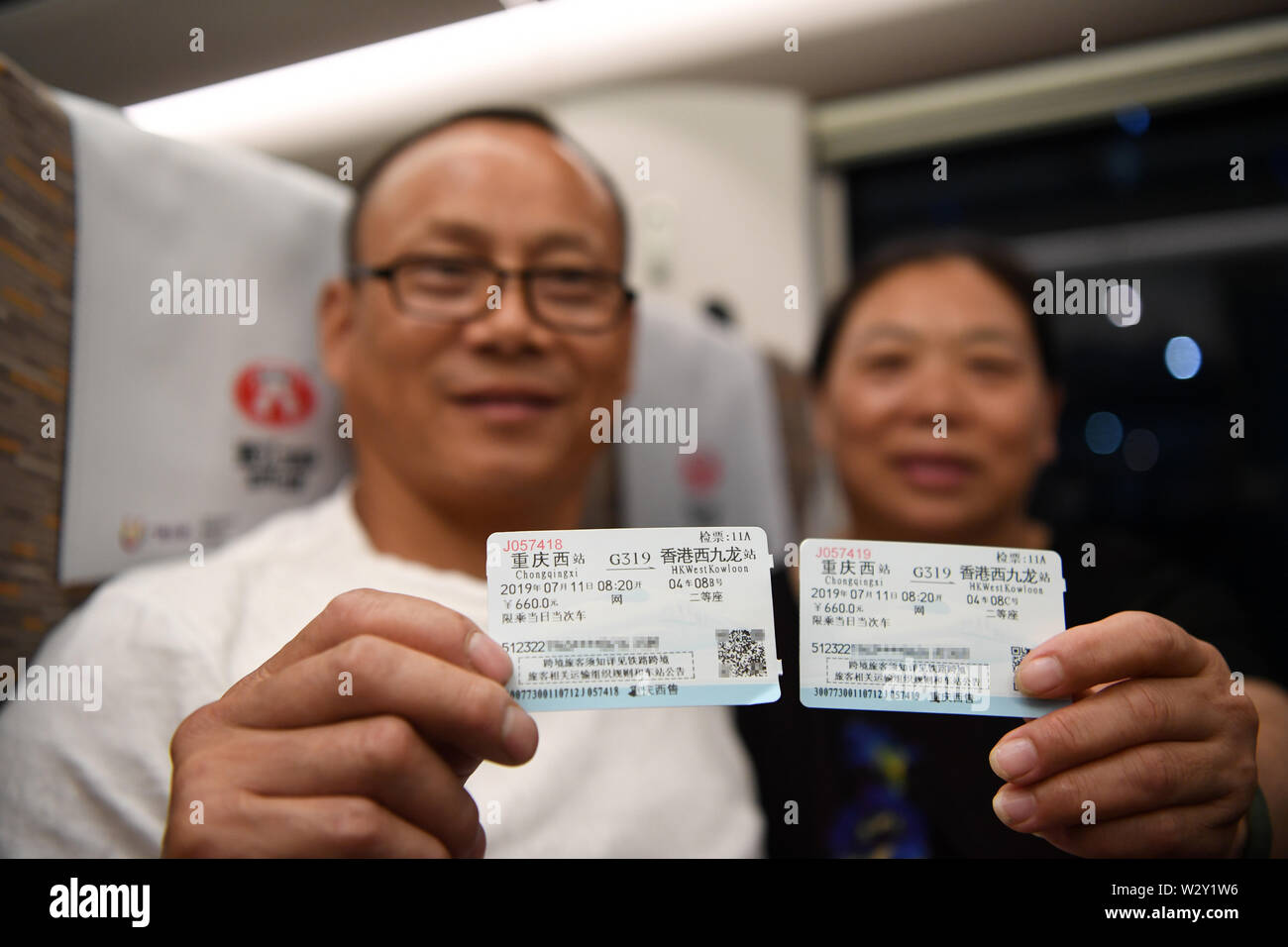 (190711) -- CHONGQING, 11 juillet 2019 (Xinhua) -- passagers montrer leurs billets à bord du train rapide G319 à la gare de l'ouest de Chongqing dans le sud-ouest de la Chine, Chongqing, le 11 juillet 2019. Le bullet train G319 a quitté la gare de l'ouest de Chongqing à 8 h 20 et arrivera à Hong Kong West Kowloon Station autour de 7,5 heures plus tard. Un siège de seconde classe pour les 7,5 heures de voiture coûte 660 yuans (environ 96 dollars américains). (Xinhua/Tang Yi) Banque D'Images