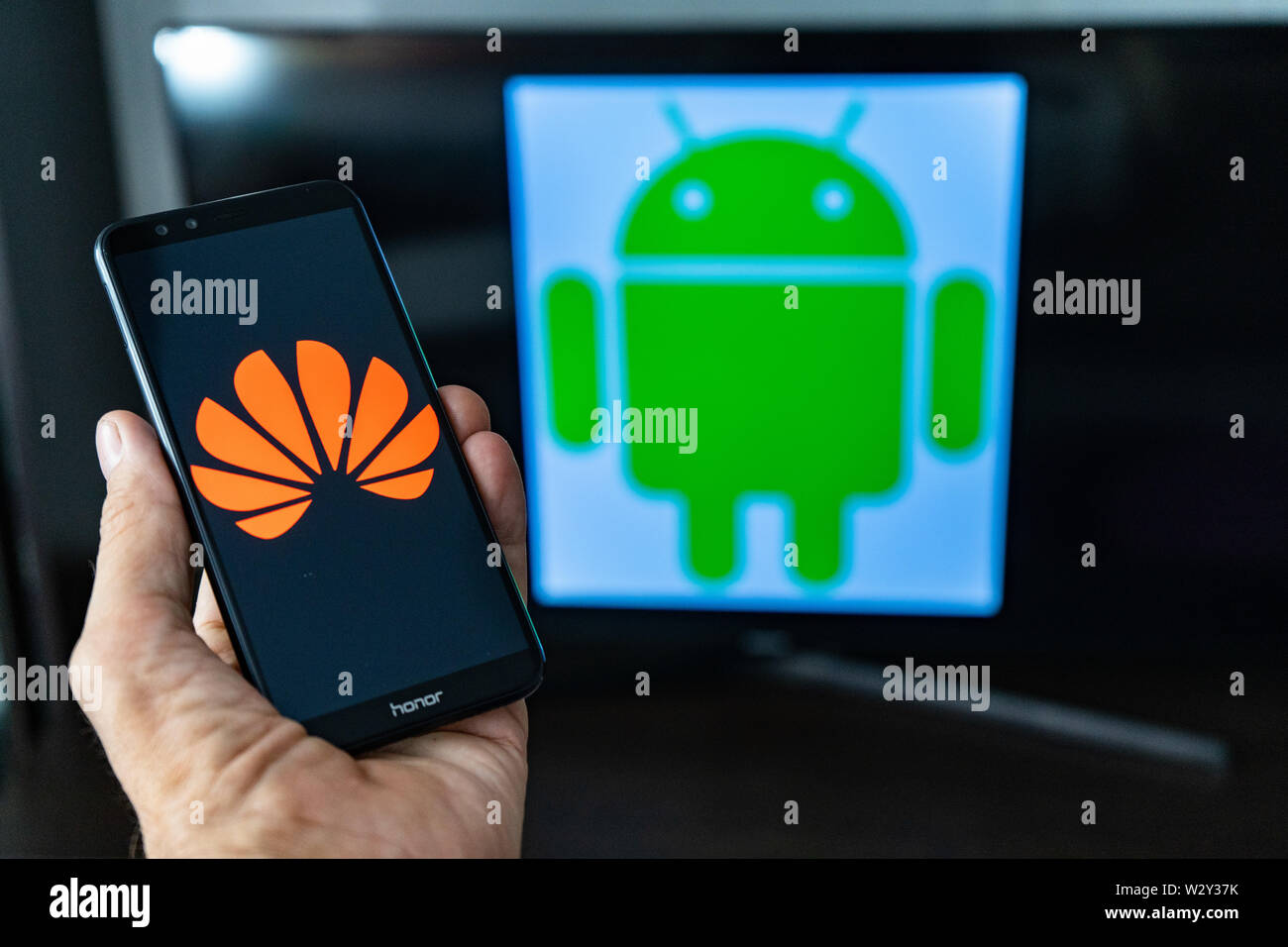 Magdeburg ALLEMAGNE - Juin 2019 : un homme tenant un smartphone Android l'honneur. Sur l'écran, le logo de Huawei en face de l'Android logo. Google limiter Banque D'Images