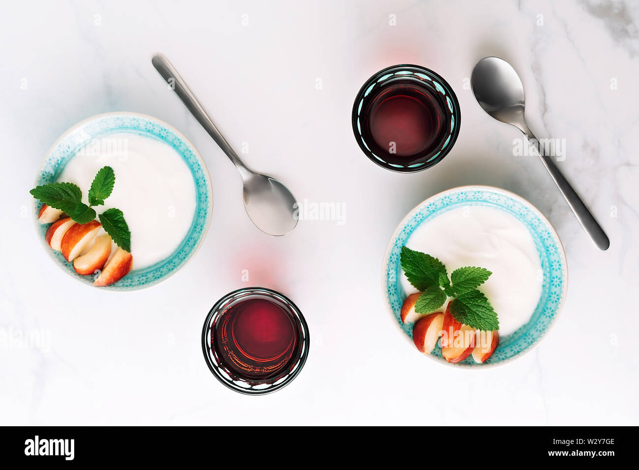 Vue de dessus du petit déjeuner sain de yaourt à la grecque, les nectarines et les jus en tableau. Mise à plat. Banque D'Images