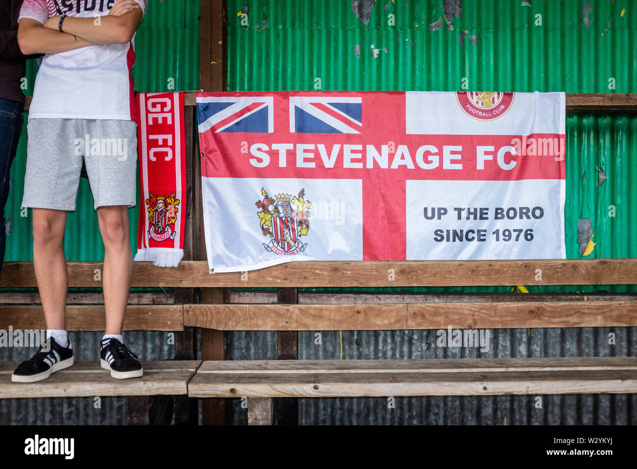 Ventilateur non identifiables, debout à côté de l'Angleterre drapeau sur la terrasse en partie en match de football Banque D'Images