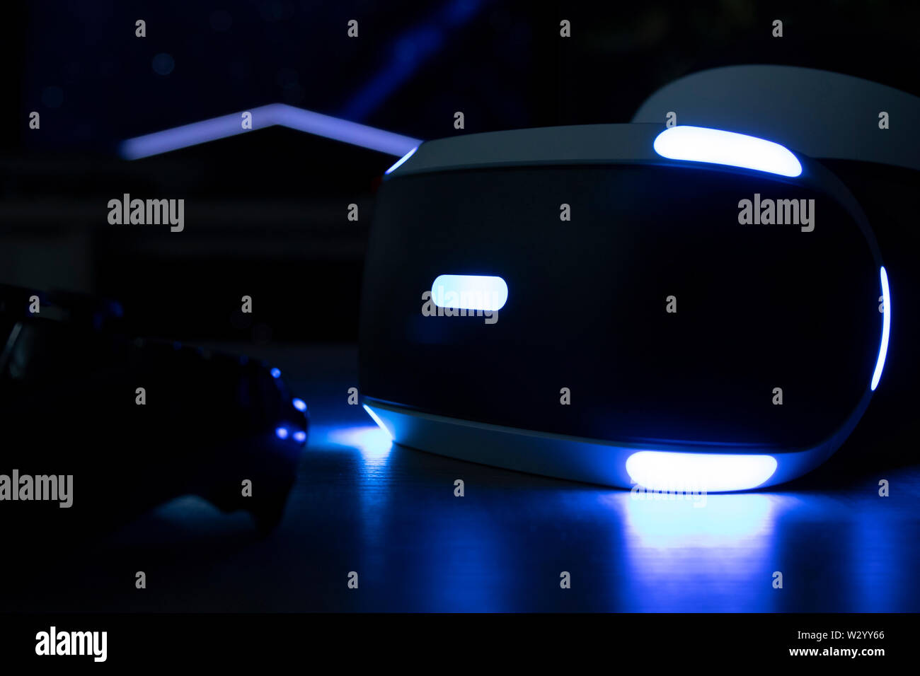 Brecht, Belgique - 12 juin 2019 : Une sombre de près de l'playstation VR casque avec ses lumières iconique activée et une playstation 4 à l'avant du contrôleur Banque D'Images