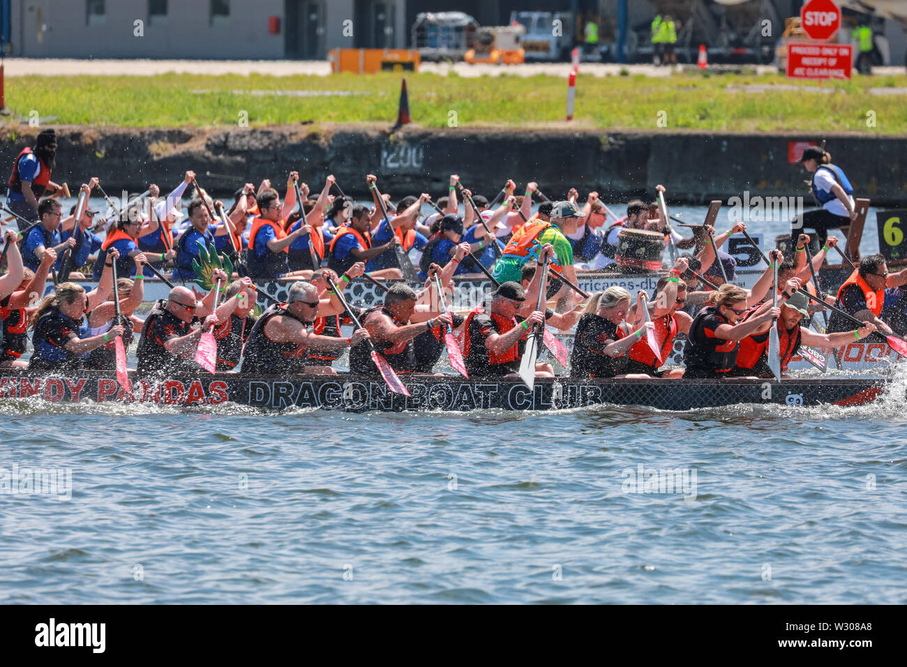 La course de bateaux-dragons les équipes s'affrontent à Londres Hong Kong Dragon Boat Festival dans le magnifique soleil, Royal Docks à Londres, Royaume-Uni Banque D'Images