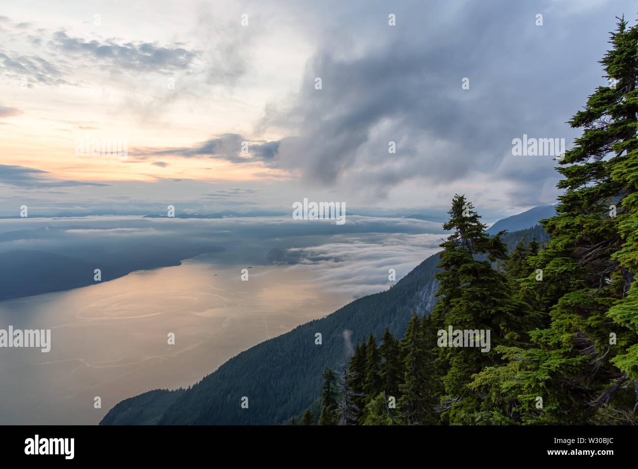 Belle vue du paysage de montagne couvert de nuages pendant un été animé coucher du soleil. Pris sur le dessus de la Sommet, West Vancouver, Brit Banque D'Images