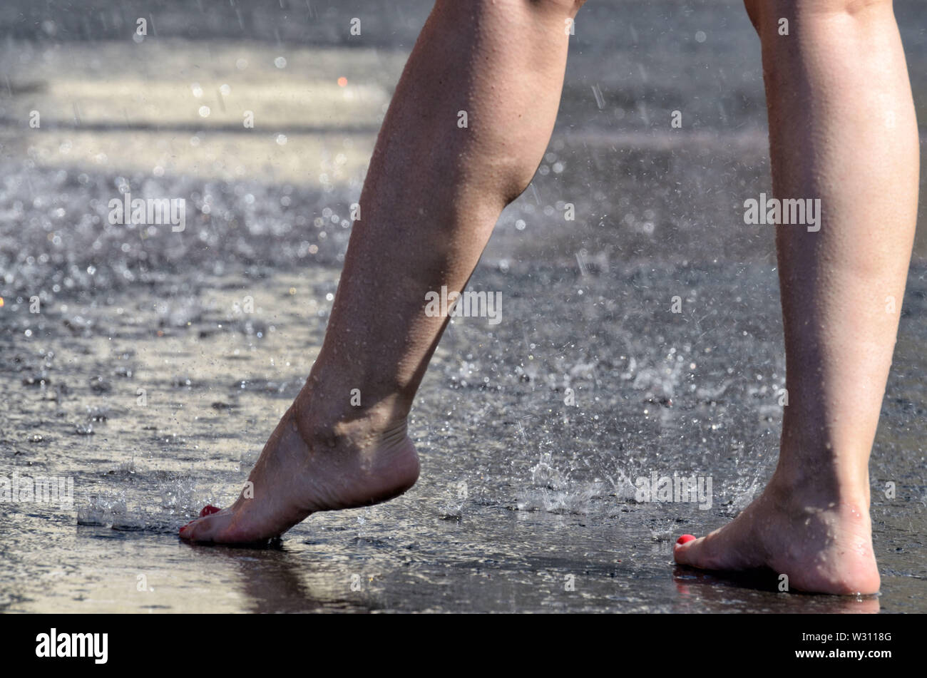 Marcher pieds nus sous la pluie dans les flaques.Il est agréable et saine. Banque D'Images