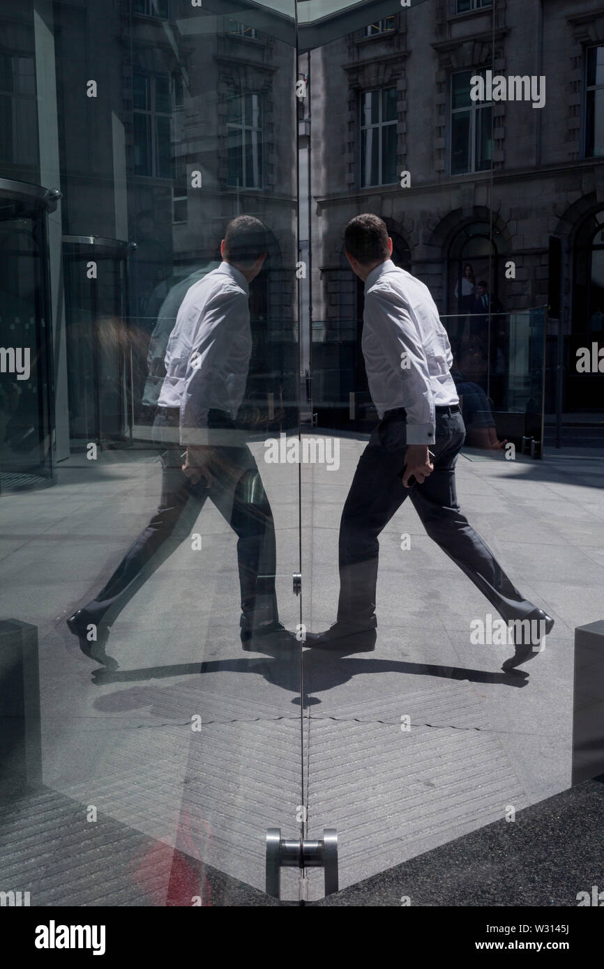 Un homme d'affaires de l'industrie financière passe devant la sculpture intitulée City Wing sur Threadneedle Street dans la ville de Londres, le quartier financier de la capitale (aka le Square Mile), le 11 juillet 2019, à Londres, en Angleterre. L'aile est de la ville par l'artiste Christopher Le Brun. Les dix mètres de haut est la sculpture en bronze par le président de la Royal Academy of Arts, Christopher Le Brun, commandé par Hammerson en 2009. Elle est appelée 'La Ville' de l'aile et a été jeté par Morris Singer, fondateurs de l'art réputé pour être la plus ancienne fonderie d'art dans le monde. Banque D'Images