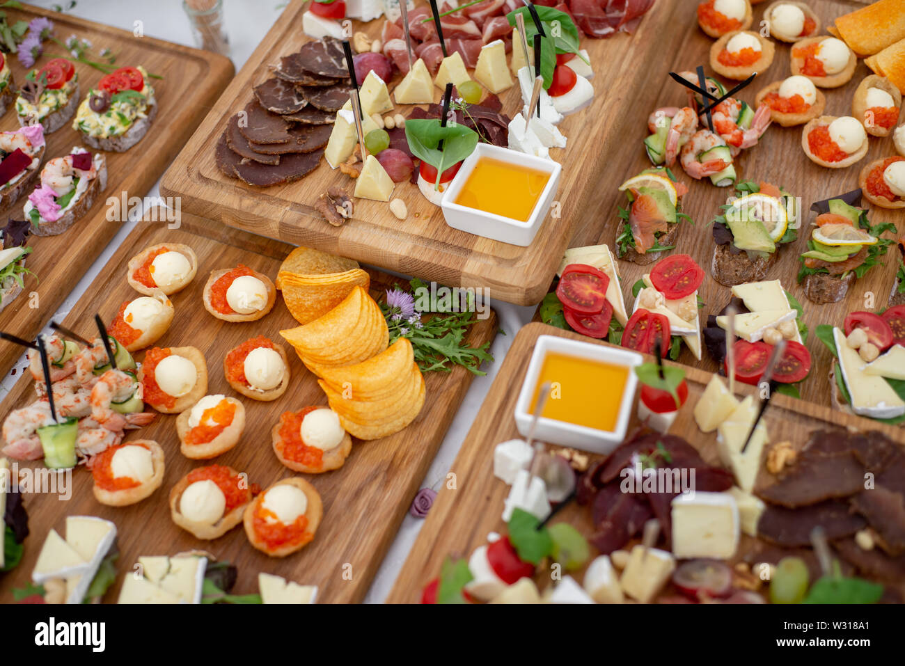 Grande sélection d'aliments contenant des collations froides, salades, charcuterie, fromage et confiture servi. Variété de délicieux en-cas savoureux sur la table. Réception de Mariage Banque D'Images