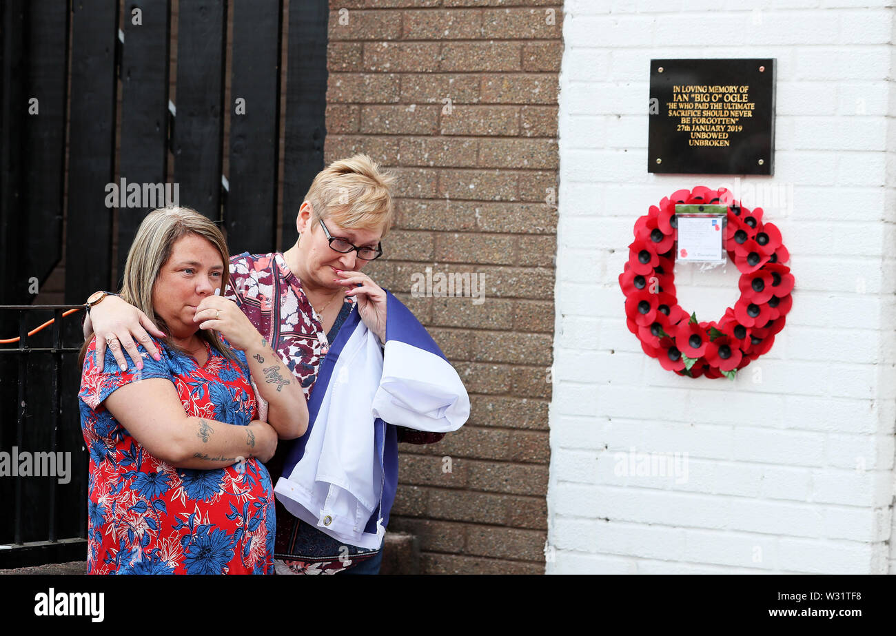 Partenaire de l'assassiné un travailleur communautaire Ian Ogle, Vera (à gauche), lors d'un événement dans Cluan Place, Belfast, tenue en sa mémoire à la veille de la douzième de juillet, à une courte distance de l'endroit où il a été agressé et tué en janvier. Banque D'Images