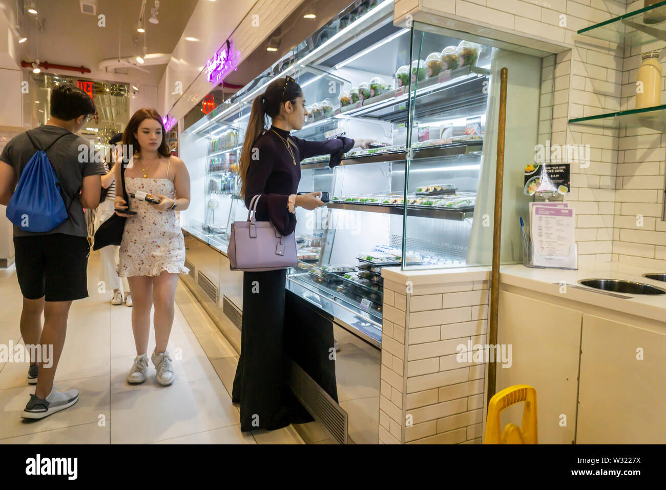 Diners choisir leur déjeuner dans le restaurant de sushi cafe SnowFox dans le quartier Flatiron de New York le Mardi, Juillet 2, 2019. Basé au Royaume-Uni Yo ! Sushi fera l'acquisition de Houston en fonction de l'opérateur, SnowFox 700 kiosques sushi fond principalement dans les supermarchés. (© Richard B. Levine) Banque D'Images