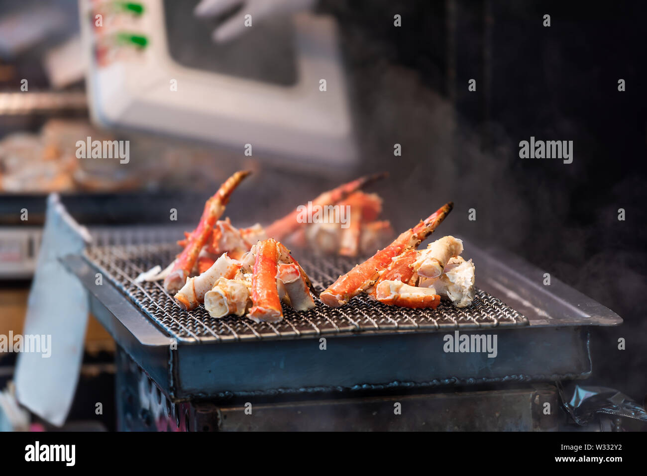 Tokyo, Japon dans l'alimentation de rue Marché aux poissons Tsukiji à Ginza avec affichage gros plan sur les jambes de homard grille de cuisson grill Banque D'Images