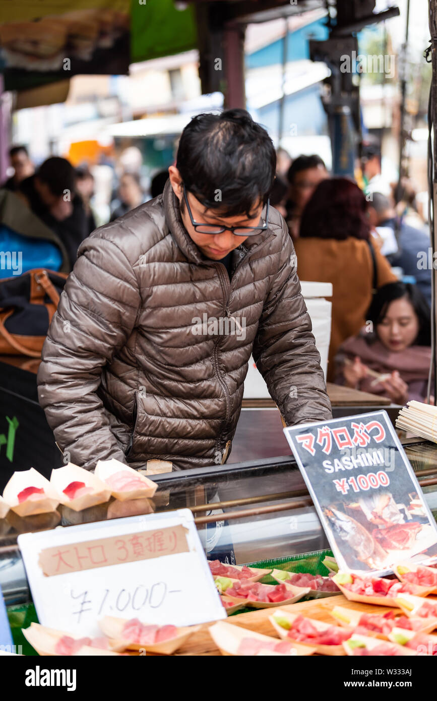 Tokyo, Japon - 30 mars 2019 : marché de Tsukiji en extérieur à Ginza avec du thon et du vendeur vendeur wasabi sashimi homme travaillant sur l'affichage de détail Banque D'Images