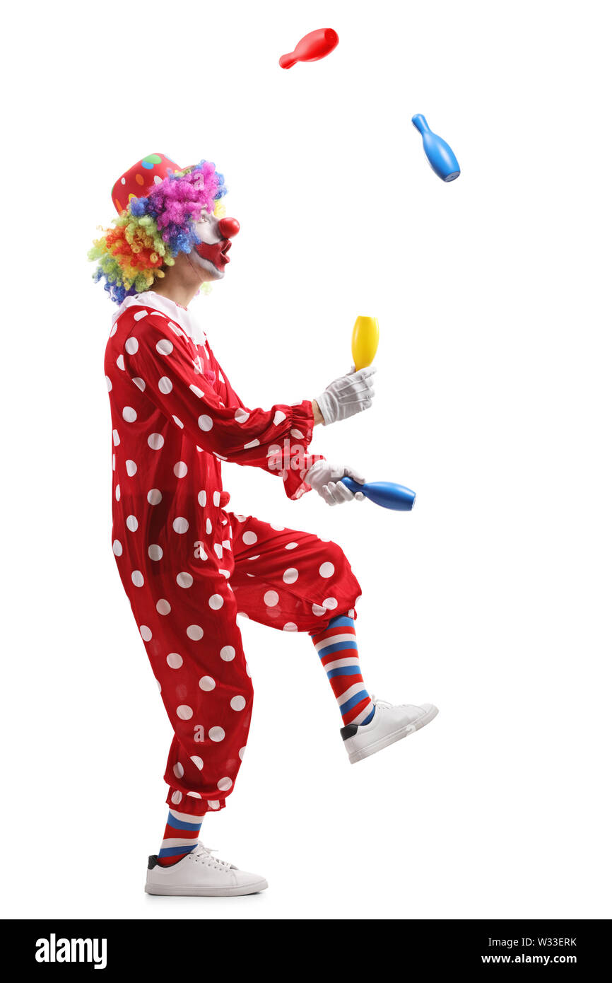 De toute la longueur d'un clown jonglant avec les clubs isolé sur fond blanc Banque D'Images