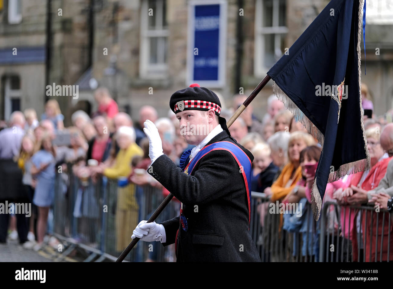 Jedburgh, Ecosse, Royaume-Uni. 12 juillet 2019. Jethart Callant Festival du Jour 2019 Jethart Callant Euan Munro, des vagues à la foule pendant qu'il marche en place l'abbaye de Jedburgh, au cours de l'Jethart Callant Festival du jour, un festival annuel, une partie de la saison de conduite commun écossais, le vendredi 12 juillet 2019, Jedburgh, Scottish Borders, Scotland, Royaume-Uni. Fentes côtés. Crédit : Rob Gray/Alamy Live News Banque D'Images