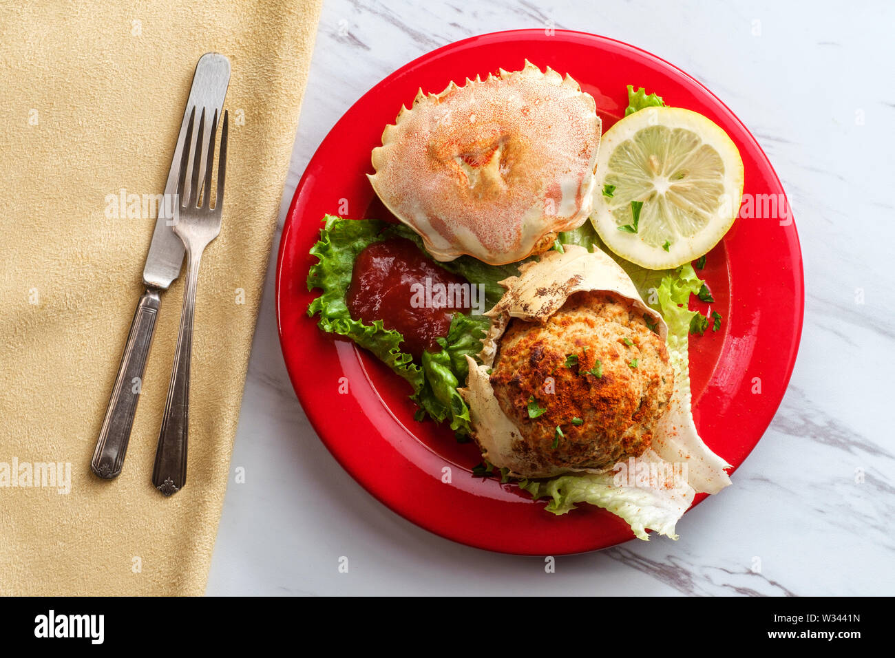 Les carapaces de crabe farci garni de laitue romaine et tranches de citron avec la sauce cocktail Banque D'Images